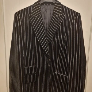 Svartsilvrig blazer från Tiger of Sweden  - En statement blazer i sammet som inte går att köpa längre från Tiger of Sweden. Perfekt för dig som vill sticka ut med en cool och elegant look. Ca 8000 kr i inköpspris. Väldigt sparsamt använd då jag växt ur den. 
