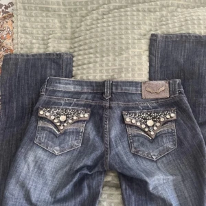 Lågmidjade bootcut jeans - Ett par bootcut jeans med låg midja och coola fickor! Säljer eftersom att de inte kommer till användning💕Midjemått rakt över:38 cm Innerbenslängd: 82 cm Grenhöjd: 17 cm