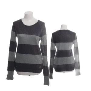 Randig tröja från Loiza by Patrizia Pepe - Mysig långärmad tröja från Loiza by Patrizia Pepe med breda mörkblå och grå ränder. Tröjan har en rund halsringning och är stickad med glittriga inslag som ger en extra touch. Perfekt för dig som gillar en chill men ändå snygg stil.