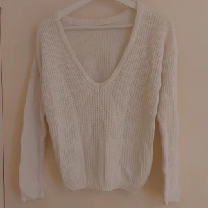 Vit stickad open back tröja från NA-KD - Vit stickad tröja från NA-KD i storlek XXS. Tröjan har en djup v-ringning baktill, ribbad struktur och långa ärmar. Perfekt för chill höst- och vinter tröja. 