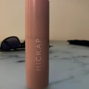 Hickap Bronzer Stick Hot Chocolate - Bronzer och contour stick från Hickap i färgen Hot Chocolate. Kommer i en smidig rosa tub med vridfunktion. Krämig formula som är lätt att blenda ut för en naturlig solkysst look. Perfekt för att skulptera och ge värme till ansiktet. Andvänd ett par gånger och är i bra skick!!