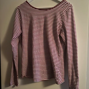Randig långärmad topp från H&M - Säljer en långärmad topp från H&M med röda och vita ränder och öppen djup rygg. Jättefin och helt oanvänd, har bara dragit bort lappen. Har klippt bort storleken men det är en uppskattad L💕