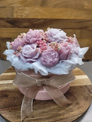 Rosa ljusbukett i box - Unik presentask fylld med handgjutna ljus i form av rosor och pioner i olika nyanser av rosa och lila. Dekorerad med torkade blommor och inslagen i vitt silkespapper, samt en glansig rosett i beige. Perfekt som dekorativt inslag på sminkbordet ellers som en unik present till någon. Kan göras i alla storlekar samt färg och doft.
