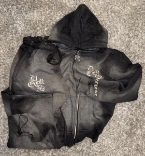 Decrese Sweden set L – svart/mörkgrått - Decrese Sweden set L – svart/mörkgrått Snyggt hoodie- och byxset i mjuk bomull med stretch och broderade detaljer. Byxor: midja 30–42 cm, innerben 68 cm, ytterben 94 cm, flera fickor. Hoodie: axel 50 cm, bröst 50 cm, längd 64 cm, ärm 60 cm. Storlekar XS–XL. Skickas inom 1–2 dagar. Köparen står för returfrakt.