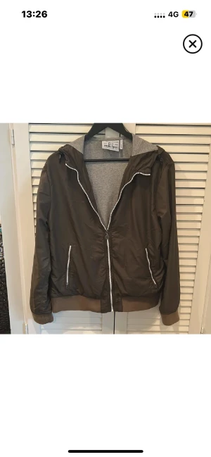 Woolrich Jacka - Snygg olivgrön vindjacka från Woolrich med grått foder i luvan. Jackan har dragkedja framtill och på fickorna, ribbade muddar och en loose passform. Perfekt med huva och stilrena detaljer i silver. Passar dig som gillar enkel och clean stil. Storlek XL i JR men sitter som en M i herrstorlek 