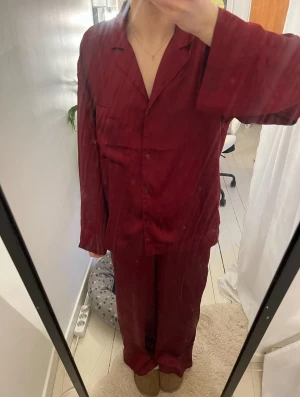 Vinröd satinpyjamas - Vinröd satinpyjamas i storlek XS från H&M. Använd men fortfarande i fint skick. Perfekt nu till julen.