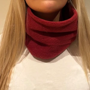 Mörkröd fleecehalsduk - Säljer en mjuk och varm mörkröd halsduk i fleece. Den har en enkel, rundad form som sitter skönt runt halsen och är perfekt för kalla dagar. Färgen är djup och snygg, och materialet är riktigt skönt mot huden. FINNS ÄNDAST 6 KVAR I DENNA FÖRG!