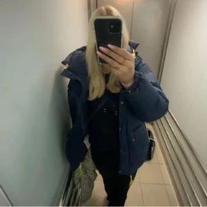 Marinblå Fjällräven pufferjacka XXS - Säljer en marinblå Fjällräven jacka med gul snörning i huvan och nederkant eftersom jag skaffat en annan. Har tagit väl hand om den och använt några fåtal gånger. Nypris 7 495kr💕