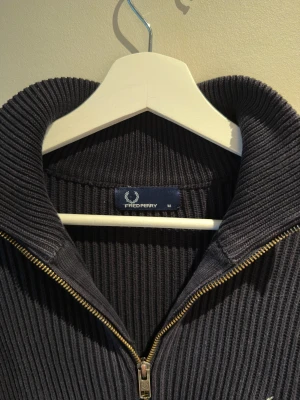 ZipUp från Fredperry - Säljer en stickad mörkblp ZipUp ifrån Fredperry, storlek M. Skicket är använt men bra.
