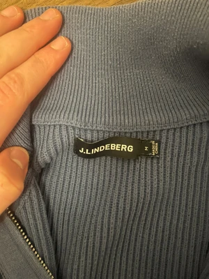 Blå stickad half zip från J.Lindeberg - Säljer min J.Lindeberg kofta. Köpt för ett år sedan, använt ett fåtal gånger. Storleken är medium men jag skulle säga att den kan passa large också. Köpt för 1400 kr på volt. Kvitto ej sparat. Pris är inte hugget i sten 😁