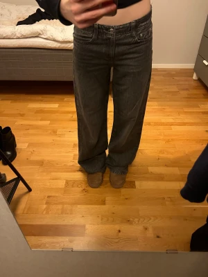 Perfekt Jeans wide fit svarta 34 - Säljer ett par svarta jeans från Perfect Jeans i storlek 34. Modellen har breda ben och klassisk femficksdesign med knapp och dragkedja framtill. Jeansen har en mörk tvätt och är tillverkade i jeansmaterial med en loose och avslappnad passform.