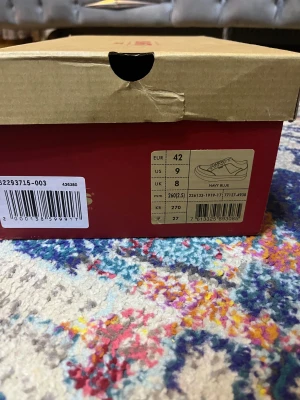 Levi's mörkblå sneakers strl 42 - Snygga mörkblå sneakers från Levi's i storlek 42. Skorna har en klassisk låg modell med vit platt sula och Levi's-logga på sidan och sulan. Ovandelen är i denimliknande textil med matchande mörkblå snörning och vita sömmar för en cool kontrast.