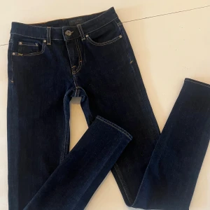 Tiger of Sweden jeans Slight 27/32 – Made in Italy (nya) - Helt nya och aldrig använda Tiger of Sweden jeans i klassiska modellen Slight. Tillverkade i Italien med premiumdenim i en mörkblå tvätt (Supra Blue Rinse) som ger en ren och tidlös look. Slim fit-passform med lätt stretch – formar sig fint utan att tappa sin form. Säljes då de aldrig kommit till användning. Riktigt bra kvalitet från Tigers italienska produktion.