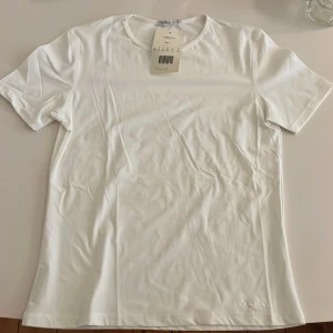 Vit t-shirt från Björn Borg  - Klassisk vit träningströja i stilren design. T-shirten har rund halsringning, korta ärmar och diskret broderad logga nertill. Tillverkad i mjukt och följsamt material som känns skönt mot huden.