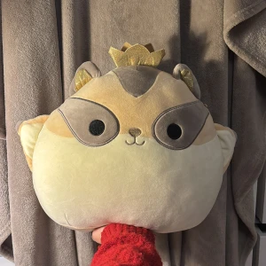 Squishmallows Kronad Ekorre - Supermjuk och gosig Squishmallows plyschdjur i form av en ekorre med krona. Perfekt som kudde eller dekoration. Originaletikett finns kvar. Fint skick, inga synliga defekter eller slitage. Passar både barn och vuxna som älskar mjuka gosedjur.