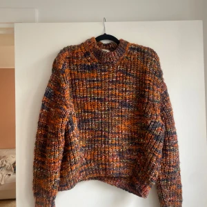 Stickad färgglad tröja Acne Studios - Säljer en chunky stickad tröja från Acne Studios i mixade färger som orange, brun och blå. Tröjan har en loose fit, hög hals och långa ärmar. Perfekt för höst och vinter när man vill vara både varm och snygg. Nypris 2500kr