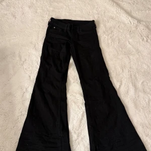 Svarta lågmidjade bootcut jeans från Cheap Monday - Säljer ett par svarta jeans från Cheap Monday med bootcut passform och väldigt låg midja. Dom är aldrig använda. Längd 101cm bredd 35cm rakt över