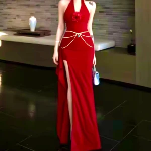 Vinröd långklänning med slits och ros + 2 present ( 1 mask + 1 midja kedja i bild) - Supersnygg vinröd långklänning med halterneck och djup slits framtill. Klänningen har en dekorativ ros vid urringningen och en figurnära passform som framhäver siluetten. Perfekt för dig som vill sticka ut med en elegant och trendig look.