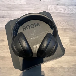 MIIEGO Moove 45i Pro - Black - Snygga och bekväma MIIEGO Moove 45i Pro trådlösa over-ear hörlurar i svart. Levereras med originalförpackning. Hörlurarna ser ut att vara i gott skick utan synligt slitage eller defekter. Perfekt för musik, träning och samtal med lång batteritid och hög ljudkvalitet. Man får med ett par extra öronstycken. Laddare ingår tyvärr inte pga att jag har tappat bort den men det är en vanlig laddare som man använder till de nya iphone 16 och PS5.