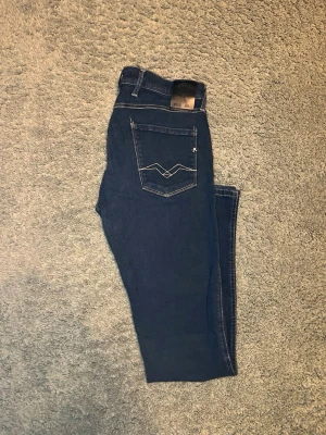 Replay Anbass W30 L32 - Säljer ett par mörkblå Replay Anbass i fint skick byxorna är i storlek W30 L32. Kom PM för fler frågor eller bilder! Priset går att diskuteras!