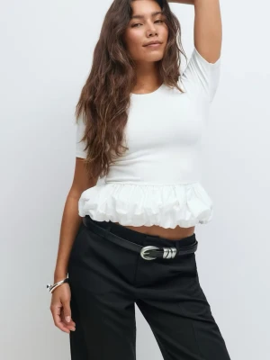 Vit volangtopp  - Säljer en söt vit topp från Gina med korta ärmar och volang nertill. Toppen har en rund halsringning och är tillverkad i mjukt bomullsmaterial. Helt ny