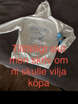 Grå hoodie French Collection - Ljusgrå hoodie med tryck i blått på ryggen. Klassisk modell med huva och snören, samt magficka framtill. Perfekt för chill dagar eller när du vill ha en avslappnad stil.  I ny skick och vi skickar den inom en vecka!