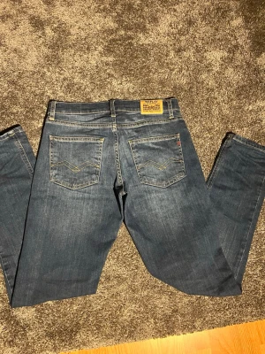 Blå jeans från Reply - Snygga blå jeans från Replay med klassisk femficksdesign och raka ben. Jeansen har diskreta slitningar framtill och kontrastsömmar. Tillverkade i denim med en autentisk tvättad look och detaljerad bakficka.