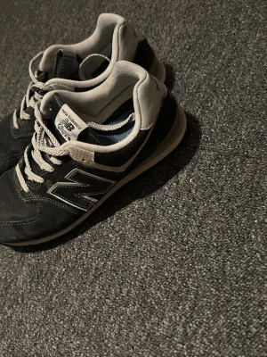 Svarta New Balance  sneakers - Snygga svarta New Balance 373 sneakers med vita detaljer och grå insida. Skorna har klassisk mesh och mocka på ovandelen, samt den ikoniska N-loggan på sidan. Perfekta för en sportig och avslappnad stil.