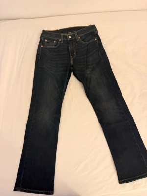 Mörkblå Levi's flaref jeans - Snygga mörkblå jeans från Levi's med klassisk bootcut passform och kontrastsömmar. Femficksmodell med detaljerade bakfickor och läderpatch bak i midjan. Tillverkade i slitstark denim, perfekta för en trendig och avslappnad look.