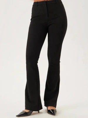 Svarta bootcut kostymbyxor - Snygga svarta kostymbyxor med bootcut-snitt och hög midja. Byxorna har klassiska pressveck, bälteshällor och stängs med dragkedja och knapp. Perfekta för en stilren look och passar till många olika outfits. Knappt använda endast ett fåtal ggr, så märken för användning finner jag ej.