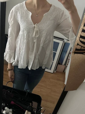 Vit romantisk blus med knytband - Supersöt vit blus från Odd Molly med smock upptill och knytband vid halsen. Blusen har v-ringning, volangiga långärmar och är gjord i ett tunt, luftigt material. Skriv gärna vid frågor!💕