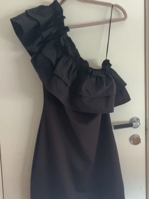 Svart one shoulder klänning med volang - Svart klänning one shoulder med stor volang, så så finnoch i jättebra skick!