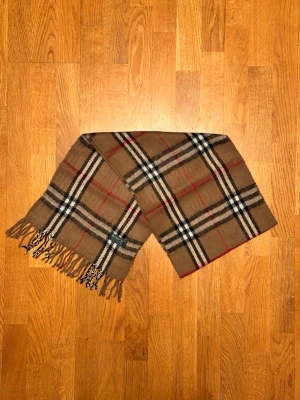 Beige Burberry halsduk - Säljer en beige halsduk från Burberry. Halsduken är i gott skick och är gjord i 100% kashmir. Var inte rädd för några frågor. Pris diskuteras inte!