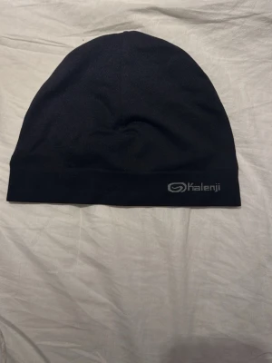 Kalenji mössa  - Säljer en svart kalenji mössa. Storlek onesize. Endast 99kr!!!!