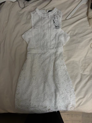 Vit spetsklänning från Boohoo - perfekt studentklänning  - Superfin vit spetsklänning från Boohoo med hög hals och ärmlös design. Klänningen har vackra spetsdetaljer och markerad midja för en snygg siluett. Perfekt studentklänning 🥰 Endast provad 