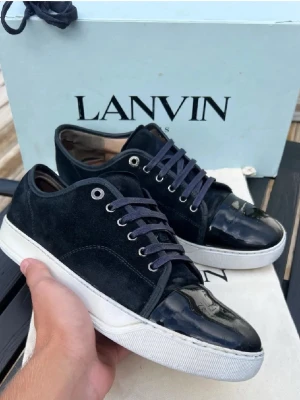 Svarta sneakers från Lanvin - Tja! Säljer nu dessa sjukt snygga och populära Lanvinsen|| Skick 8/10 endast slitet inuti skon som du kan se på bild 4 och lite sliten mockal| Färg Mörkblå|| Storlek Uk 9 vilket passar dig som har storlek 44 eul| Innersulans längd är 29,5cm||BOX, DUSTBAG och de gamla snörena följer med vid köp|| Om du har några frågor eller funderingar är det bara att höra av sigl|