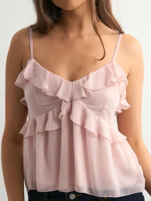 Ljusrosa volangtop med tunna axelband - Söt ljusrosa topp med volangdetaljer och tunna axelband. Toppen har en luftig och flowy passform, perfekt för varma dagar. Materialet känns lätt och ger en romantisk vibe.