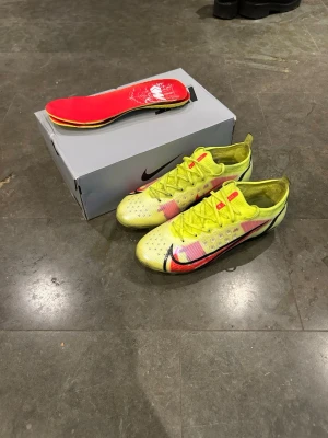 Nike Mercurial gul/röd fotbollsskor - Säljer ett par Nike Mercurial fotbollsskor i neon-gult med röda och svarta detaljer. 