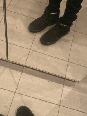 Svarta kängor från Tommy Hilfiger - Snygga svarta kängor från Tommy Hilfiger med mjukt foder och högre skaft. Skorna har snörning framtill och en diskret logga bak på hälen. Utsidan är i mockaliknande material och sulan är robust för extra grepp.