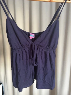 Blått linne  - Supersöt mörklila playsuit med tunna axelband och knytning framtill från märket Pyjamas. Perfekt för chill dagar hemma eller som loungewear. Mjuk och lätt bomullskvalitet som känns skön mot huden. Aldrig använd 