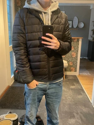 Svart pufferjacka från H&M - Säljer en svart pufferjacka från H&M i storlek S. Jackan har quiltad design, hög krage och dragkedja framtill. Perfekt för kyliga dagar och enkel att matcha med olika outfits. Klassisk och stilren modell som funkar till det mesta. Hör gärna av dig vid frågor!