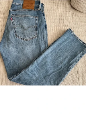 Levi's 514 blå jeans straight fit - Klassiska blå Levi's 514 jeans med straight fit och normal passform. Storlek 32,30. Jeansen har fem fickor, läderpatch bak och den ikoniska röda Levi's-taggen. Tillverkade i slitstarkt bomullsjeansmaterial. Hör av dig vid fler frågor 