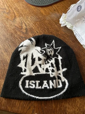 Trash Island beanie - Trash Island Beanie, osäker på äkthet Mössan är i bra skick förutom ett litet hål. Jag är osäker på om den är äkta, så jag säljer den som kollektionspryl. hör gärna av dig om du vill ha fler bilder eller detaljer