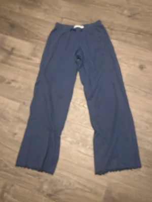 Mörkblå linnebyxor från 157 XS - Mörkblå linnebyxor från 157 med avslappnad passform och snörning i midjan. Byxorna har raka, vida ben och är tillverkade i ett luftigt linnematerial som passar perfekt för varmare dagar.