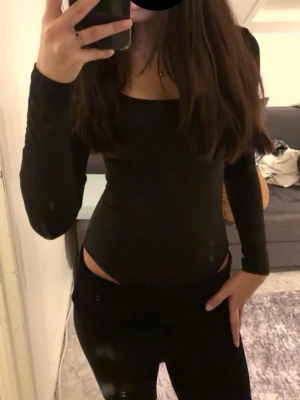 Svart långärmad body med uringat framtill - säljer min svarta urringningade body i storlek S, säljer pga rensning och aldrig används.