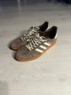 Adidas Spezial mocka sneakers brun/vit - Säljer ett par Adidas Spezial i brun mocka med vita detaljer. Perfekta för dig som gillar retrostil och vill ha något som sticker ut. Skorna funkar för att både ha inne och ute. Dem är väldigt stilrena och passar till det mesta! Skriv om du har frågor eller funderingar❓ kolla gärna in min profil för potentiella bundles😀