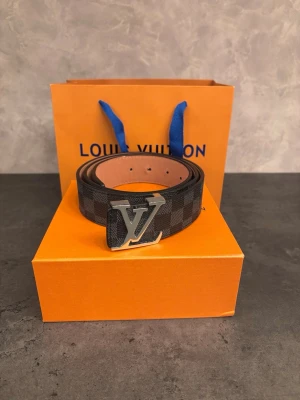 Bälte - bälte i mycket fint skick. Bältet är sparsamt använt och överlag i väldigt bra skick. Det enda att anmärka på är att det har färgat av sig lite på insidan samt att ett av hålen är något uttöjt (se bilder). Inget som påverkar användningen.  Längd: 110 cm Original box ingår.