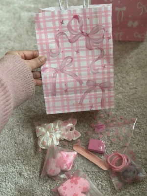 Rosa Gift set  håraccessoar-kit i rosa och vitt - Ett gulligt kit med håraccessoarer i rosa och vitt, inklusive scrunchies, hårsnoddar och hårklämmor. Allt kommer i små påsar med blom- och hjärtmotiv. Perfekt för dig som älskar söta detaljer och pastellfärger.perfect for birthdays and valentines gift