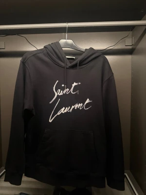 Saint Laurent Hoodie - Säljer nu denna snygga Saint Laurent hoodie som är i size L. Tveka inte att höra av dig om du undrar något eller vill se fler bilder!//Felkannn