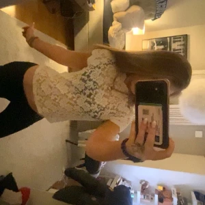 Vit spetsblus med hög krage - Säljer en vit, figurnära spetsblus med korta ärmar. Blusen har ett genombrutet spetsmönster som ger en romantisk och trendig look. Perfekt att styla med både jeans och kjol. Storleken är M men sitter bra på mig som har Xs och S